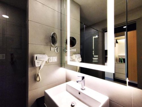 een badkamer met een wastafel en een spiegel bij TopGenting RosyColdSuite4Pax @GrdIonDelmn in Genting Highlands