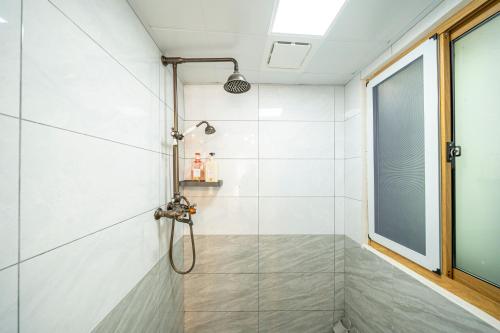 ein Bad mit einer Dusche und einer Glastür in der Unterkunft 小喜屋（西井街店） in Qingpu