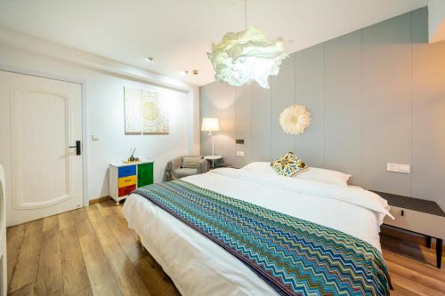 a bedroom with a large bed and a chandelier at 小喜屋（西湖街店） in Qingpu