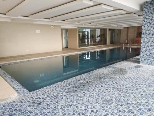 a swimming pool in a building with a tile floor at My Space in Manila