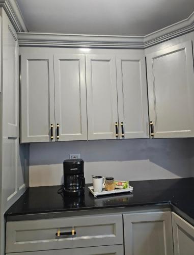 a kitchen with white cabinets and a black counter top at Secret Hideaway in Ocho Rios