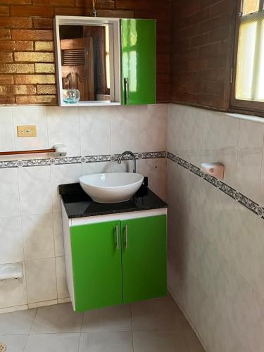 a bathroom with a sink and a green cabinet at Hotel El Bohio in Guaduas