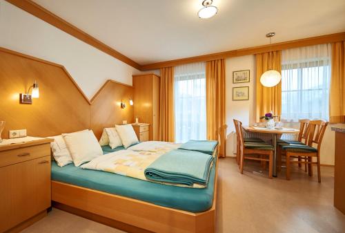 ヴァークラインにあるBauernhof Auhofのベッド、テーブル、椅子が備わるホテルルームです。