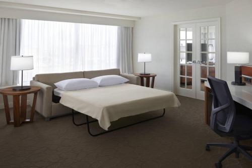a bedroom with a bed and a couch and a desk at Delta Hotels by Marriott Toronto Airport & Conference Centre in Toronto