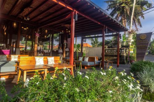 a restaurant with wooden tables and chairs and plants at Pertiwi Bisma Ubud in Ubud