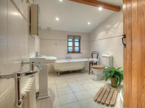 ein Badezimmer mit einer Badewanne, einem Waschbecken und einem WC in der Unterkunft Yr Hen Glowty in Little Newcastle