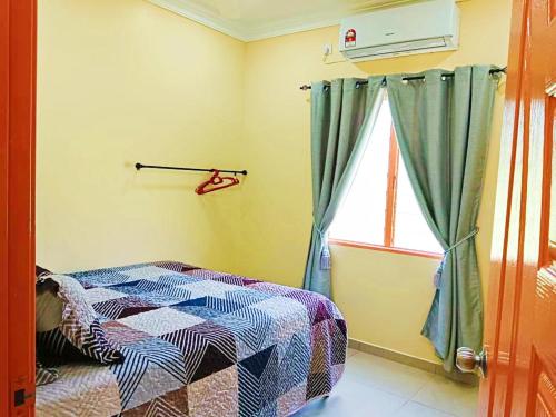a bedroom with a bed and a window at Hanani Homestay in Shah Alam