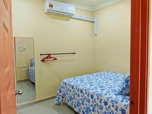 Cette petite chambre comprend un lit et un miroir. dans l'établissement Hanani Homestay, à Shah Alam