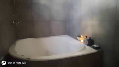a bathroom with a white sink and a candle at Cardo Ruso Cabaña in Toay