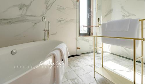 a white bathroom with a tub and a window at Party Me 派對蜜民宿 in Dongshan