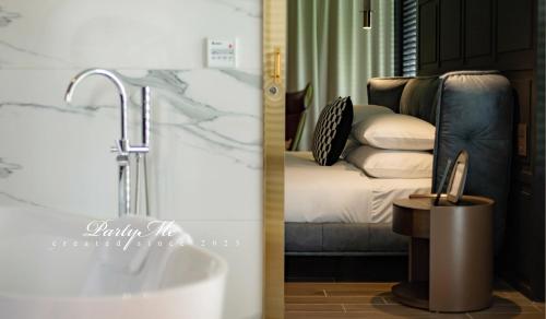 a bathroom with a sink and a bed with pillows at Party Me 派對蜜民宿 in Dongshan