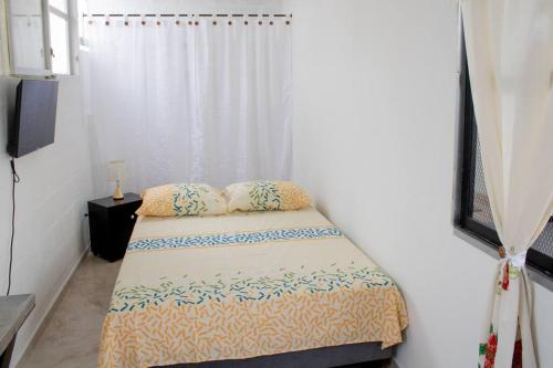a small bedroom with a bed and a curtain at Habitación ubicación perfecta y comodidad full in Cali