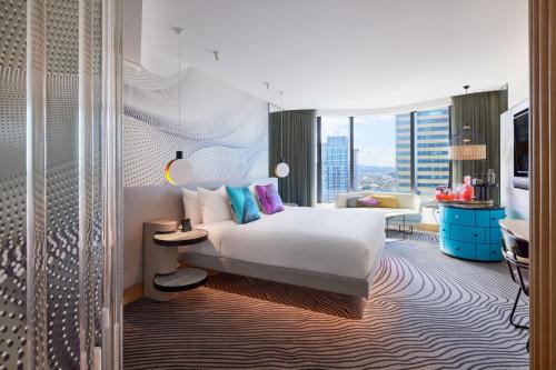 une chambre d'hôtel avec un lit et une chambre avec vue dans l'établissement W Brisbane, à Brisbane