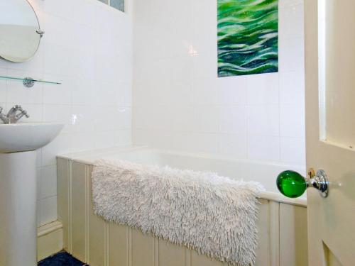 a bathroom with a bath tub with a rug next to a sink at Trefrane House-qc1119 in Roch