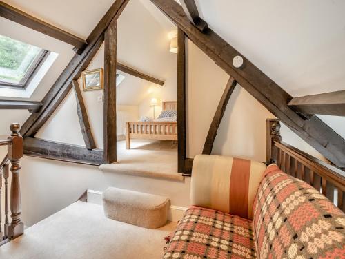a living room with a couch in the attic at The Carriage House in Llanwenarth