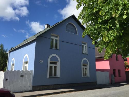 um edifício azul com janelas brancas numa rua em House in the Garden em Pärnu
