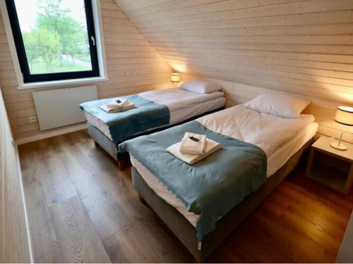 2 camas individuales en una habitación con ventana en New semi-detached house by the beach in Stepnica, en Stepnica