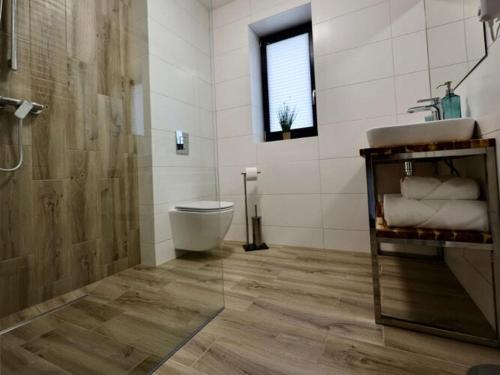 uma casa de banho com um WC, um lavatório e um chuveiro em New semi-detached house by the beach in Stepnica em Stepnica