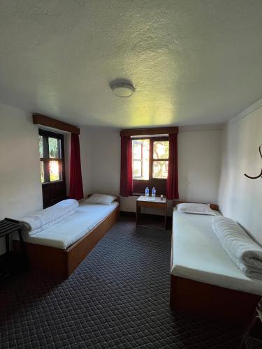 a room with three beds in it with red curtains at Bhaktapur Guest House in Bhaktapur