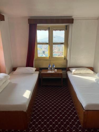 a room with two beds and a window at Bhaktapur Guest House in Bhaktapur