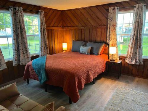 um quarto com uma cama num quarto com janelas em Cape Cod on Broad em Ashland