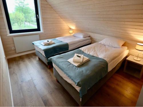 2 camas individuais num quarto com uma janela em A comfortable semi-detached house by the beach in Stepnica em Stepnica