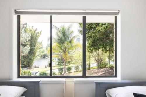 a window in a bedroom with a view of the water at Pet and family friendly- with its own lake and 3 mins from town! in Maleny