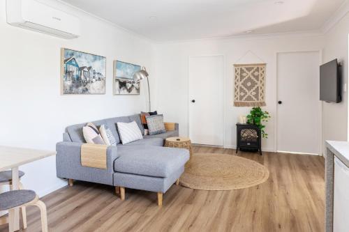 una sala de estar con un sofá y una mesa en Relax Unwind This Summer at Nordic Star with Lake View, en Maleny