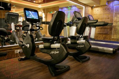 a gym with several tread machines and a television at Pałac Saturna in Czeladź