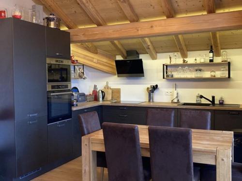 une cuisine avec une table en bois et une salle à manger dans l'établissement Bel appartement 3 pièces, 60m², 6 pers, Alpe d'Huez - Près des commerces, pistes et remontées mécaniques - FR-1-405-340, à Huez