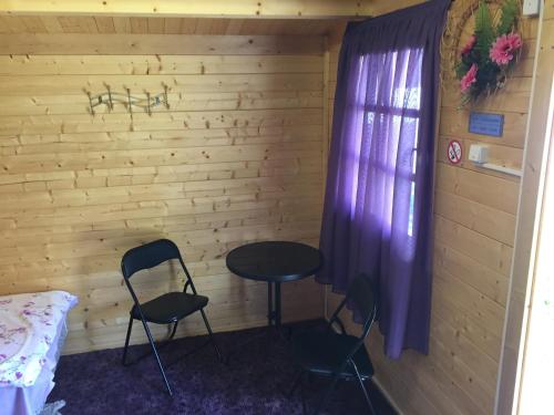 派爾努的住宿－園中屋度假公園，一间设有两把椅子、一张桌子和一个窗户的房间
