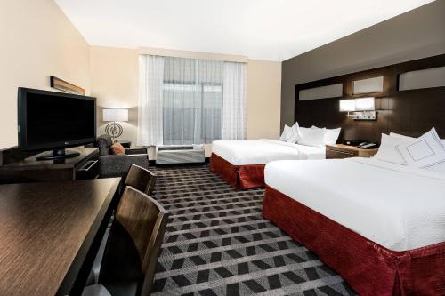 a hotel room with two beds and a flat screen tv at TownePlace Suites by Marriott San Antonio Downtown Riverwalk in San Antonio