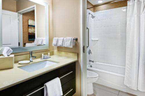 a bathroom with a sink and a toilet and a mirror at TownePlace Suites by Marriott San Antonio Downtown Riverwalk in San Antonio