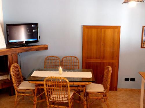 a dining room with a table and chairs and a tv at B&B Villa sul Mare in Melito di Porto Salvo