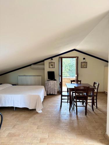 a bedroom with a bed and a table and chairs at Cumana Blu Apartments in Campofilone