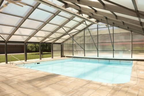 an indoor swimming pool with a glass roof at Travelodge by Wyndham Ogallala in Ogallala