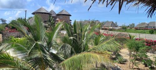 a group of palm trees in front of a building at 765 Breezebay suites in Watamu