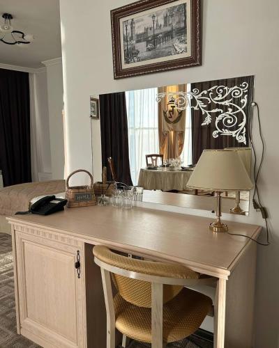 escritorio con lámpara y cama en una habitación en Tanzharyk Hotel en Aktobé