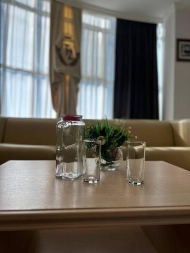 two glasses and a glass jar on a table at Tanzharyk Hotel in Aktobe