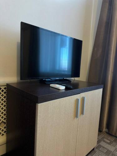 a flat screen tv sitting on top of a cabinet at Tanzharyk Hotel in Aktobe