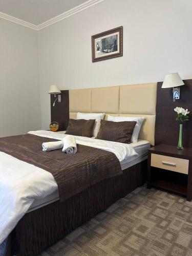 a bedroom with a large bed with towels on it at Tanzharyk Hotel in Aktobe