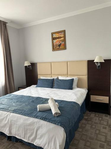 a hotel room with a bed with a towel on it at Tanzharyk Hotel in Aktobe