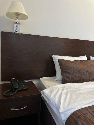 a hotel room with a bed and a desk with a lamp at Tanzharyk Hotel in Aktobe