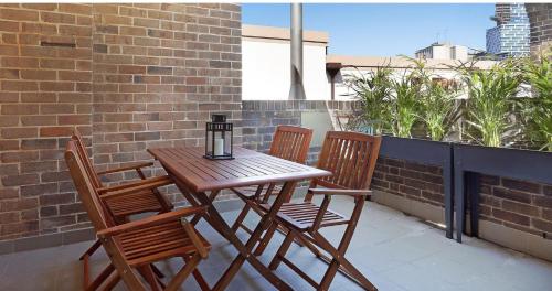 a wooden table and chairs on a balcony at Discover The Rocks - Historical Terrace House in Sydney
