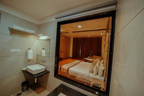 a bathroom with a bed and a sink and a mirror at IMAGICA RESORTS in Chittaurgarh