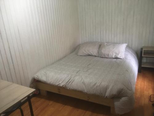 a small bed in a corner of a room at Alojamiento céntrico a pasos de todo in Coihaique