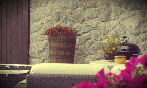 a table with flowers on top of a stone wall at Il Forno Dal 1922 in Bene Vagienna