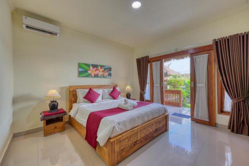 ein Schlafzimmer mit einem großen Bett und einem großen Fenster in der Unterkunft RR Cottage in Nusa Penida