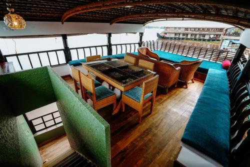 a room with a table and chairs on a boat at Why Not Houseboat in Alleppey