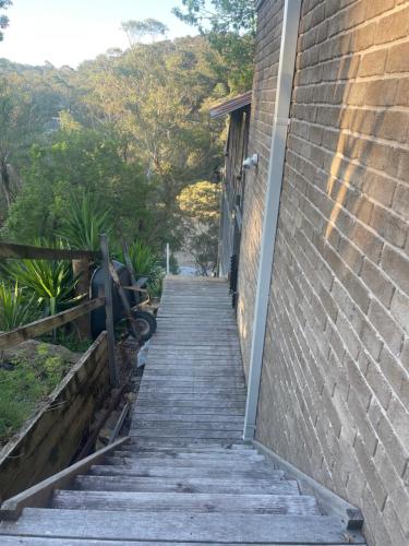 a wooden stairway leading up to a brick building at River Retreat Studio in Grays Point